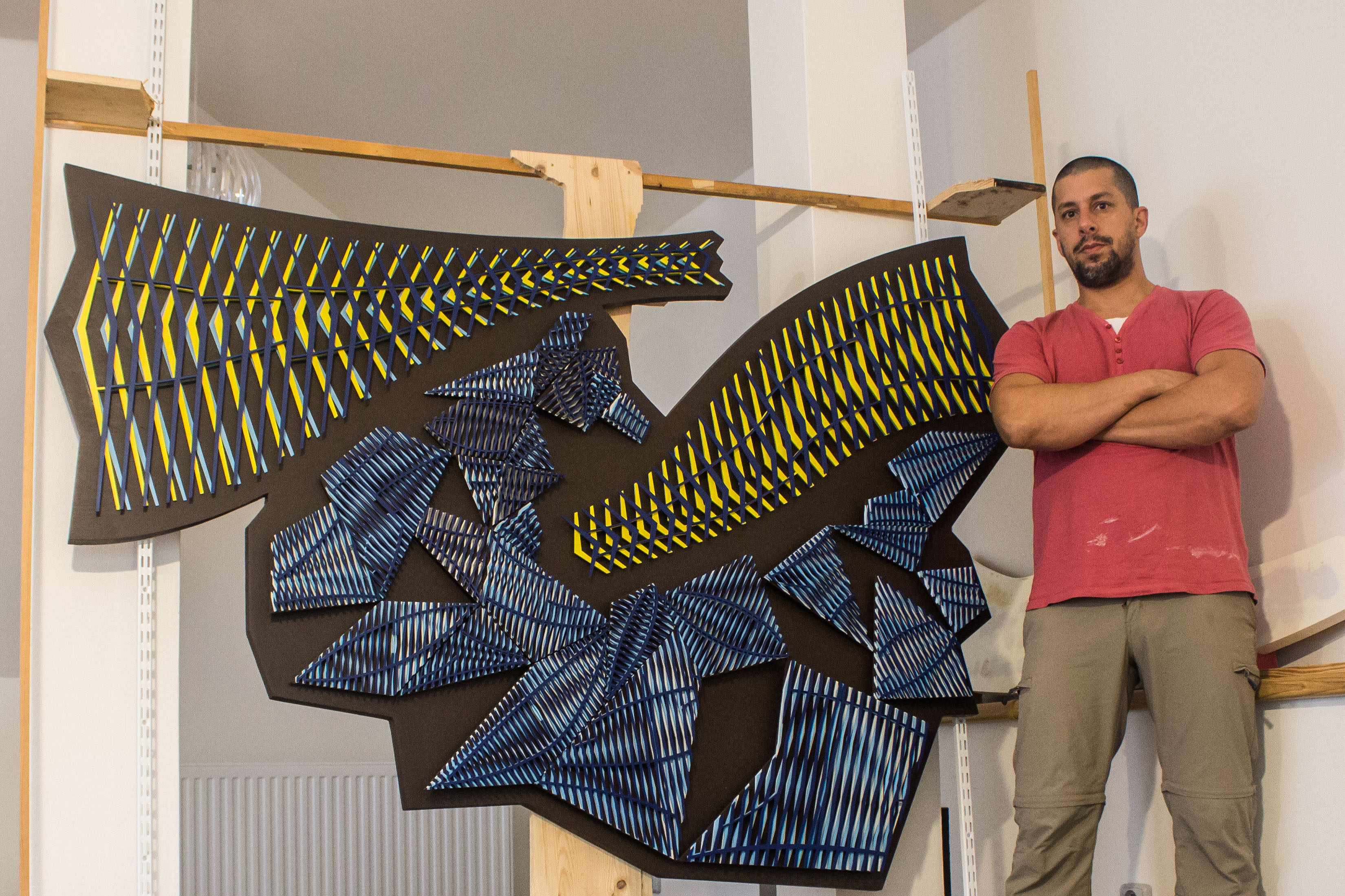 Modular geometric relief titled Aero Akvo, inspired by airflow dynamics and water condensation, composed of layered linear elements.